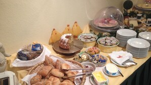 A buffet table with various food items, including bread, pastries, and cheese. - Hotel Roter Hahn - Bed & Breakfast (Garmisch-Partenkirchen)