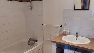 Un baño con una bañera, un lavabo y un espejo.