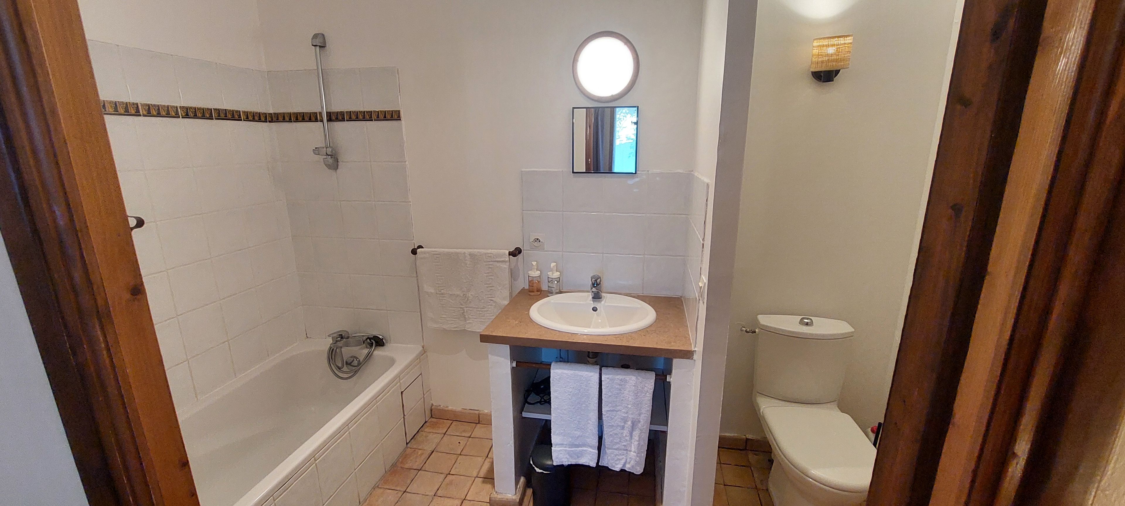Un baño con bañera, lavabo e inodoro.