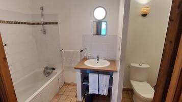 Un baño con bañera, lavabo e inodoro.