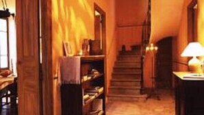 A narrow hallway with wooden doors and a staircase.