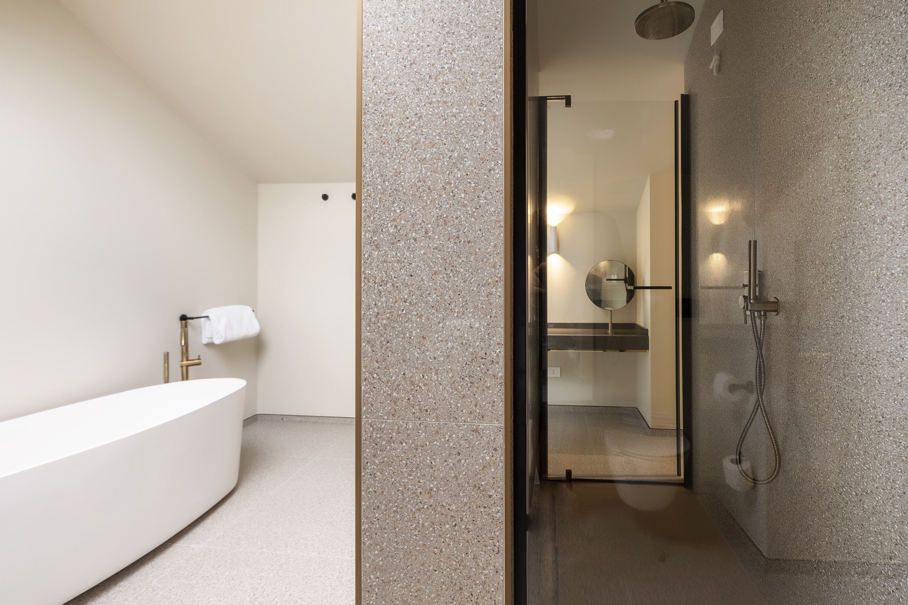 A modern bathroom with a freestanding bathtub, a glass-enclosed shower, and a visible mirror.