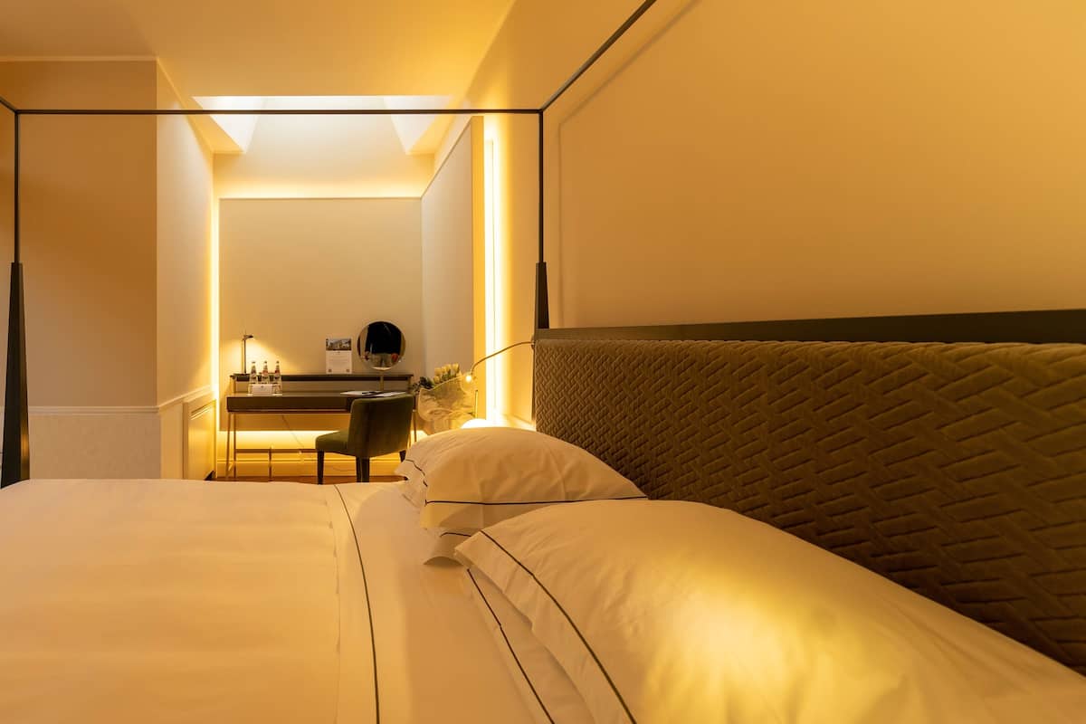 A hotel room with a bed, a desk, and a chair.