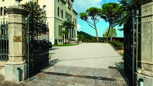 A paved driveway leading to a building with a wrought iron gate and a stone balustrade. - Hotel Villa Soligo - Small Luxury Hotels of the World (Farra di Soligo)