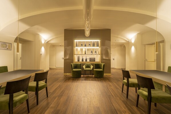 A spacious conference room with a long table and chairs, a central display case, and a high ceiling with a chandelier.