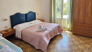 Una camera da letto con un letto, comodini, un armadio e una finestra con tende.