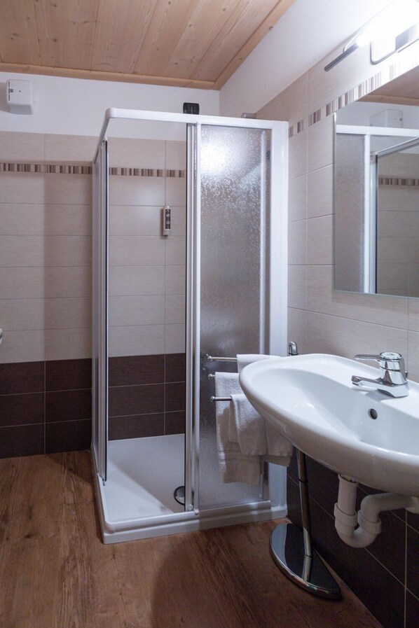 A bathroom with a glass-enclosed shower, a white sink, and a mirror above it. - Funivia Bormio Active Hotel - Adults Only (Bormio)