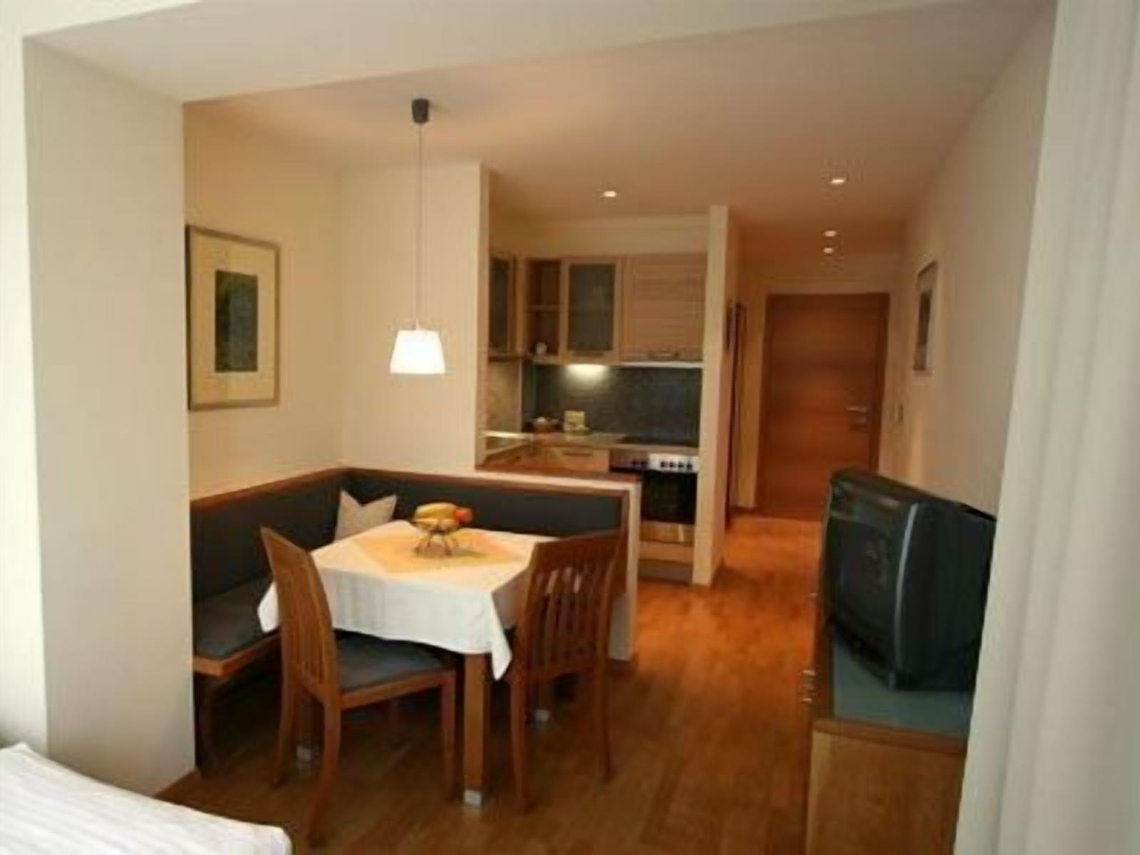 A compact living space with a dining area, kitchenette, and a small seating area.