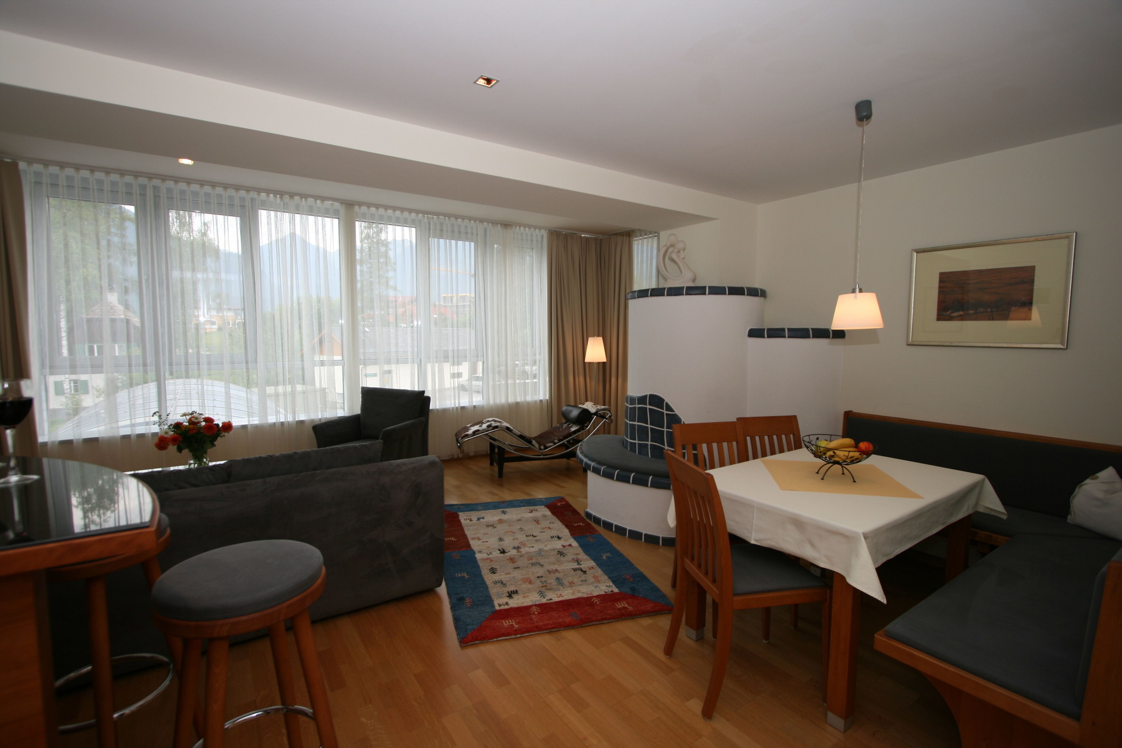 Een moderne woonkamer met een eethoek, een bank, een tafel en een bar.