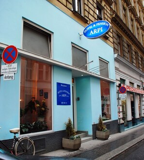 Un hotel chiamato ARPI con facciata blu, un'area reception e un cartello che indica divieto di parcheggio.