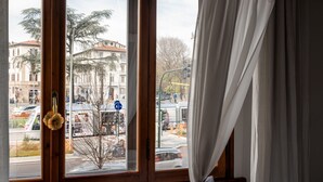 A window with a view of a street, a traffic light, and a building with a balcony. - Antica Posta Bed & Breakfast - Florence (Florence)