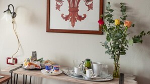 A breakfast table with a tray of food, a vase with flowers, and a framed artwork on the wall. - Antica Posta Bed & Breakfast - Florence (Florence)