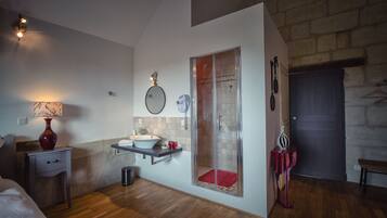 Een moderne badkamer met douche, wastafel en spiegel.