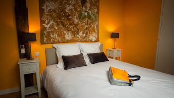 Una camera d'albergo con un letto grande, due comodini e un'opera d'arte appesa al muro.