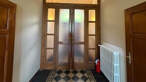 A hotel entrance with a double door, frosted glass panels, and a radiator on the right. - Villa Porta all'Arco (Volterra)