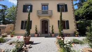 A two-story building with a central entrance, a balcony, and a gravel driveway. - Villa Porta all'Arco (Volterra)