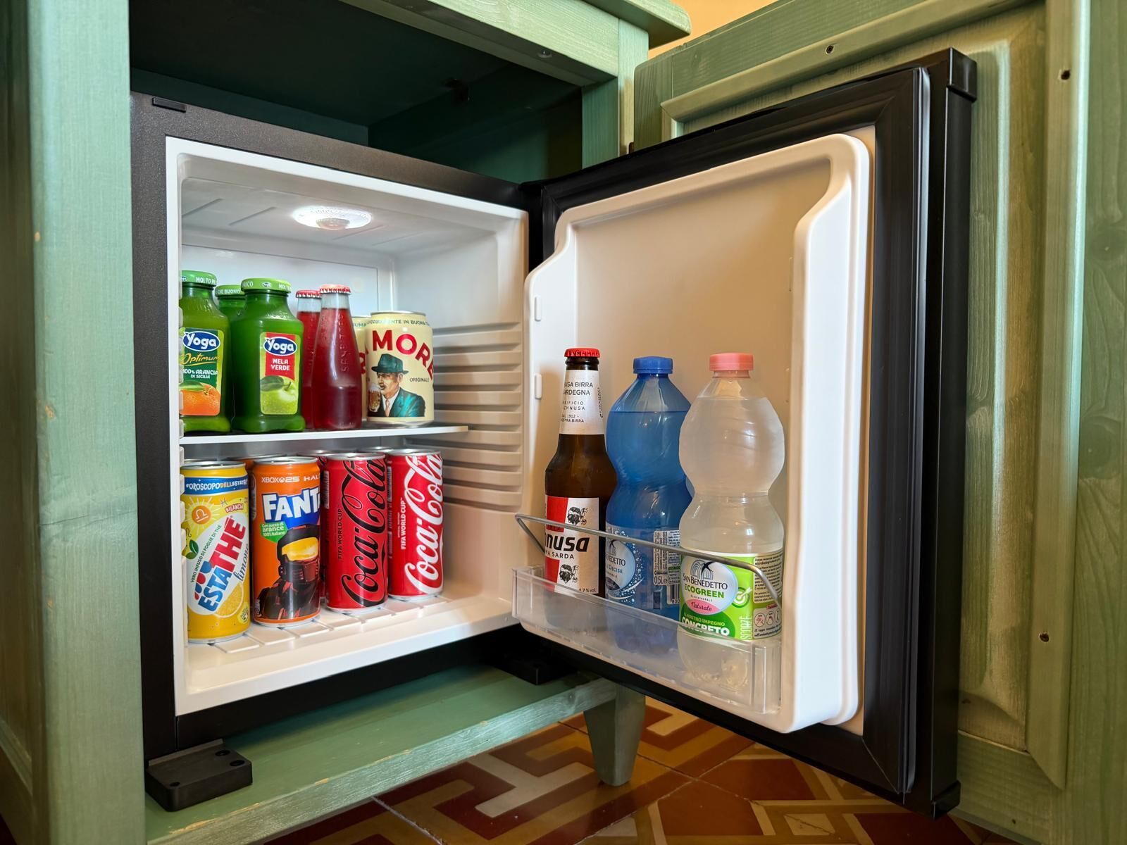 Ein offener Kühlschrank mit Getränken und Dosen.