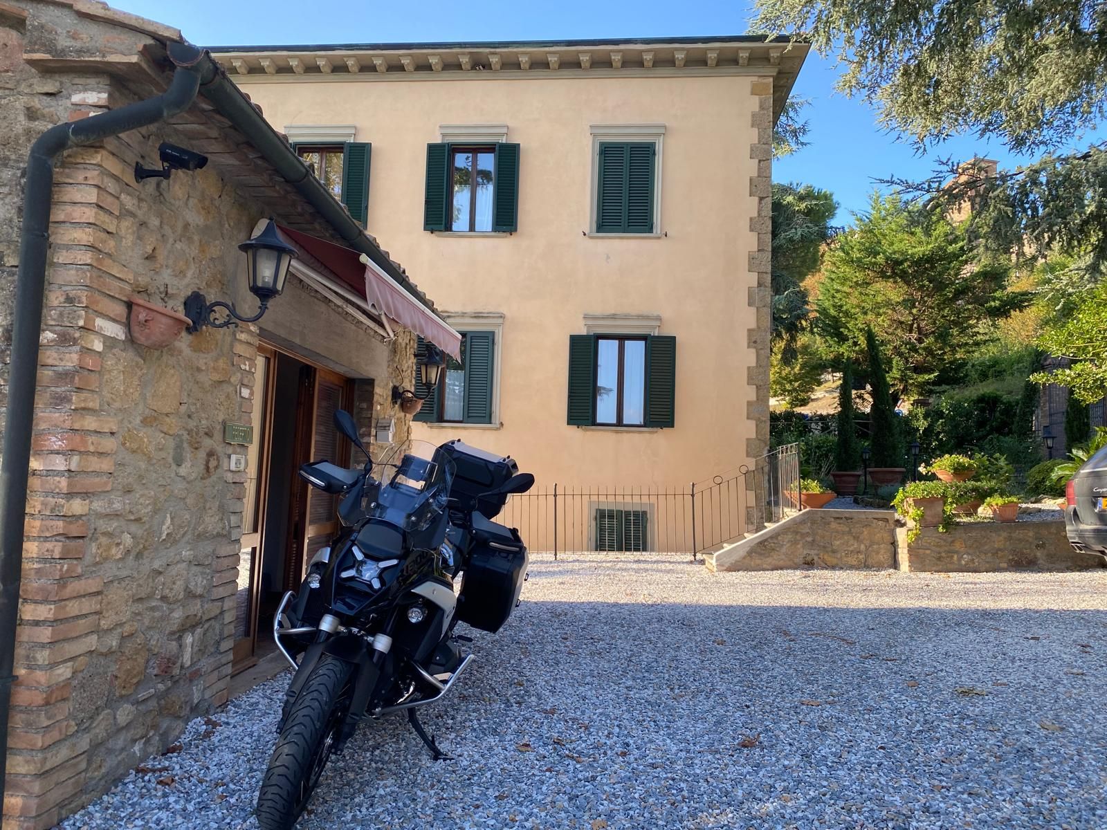 A building with a gravel driveway and a parked motorcycle.