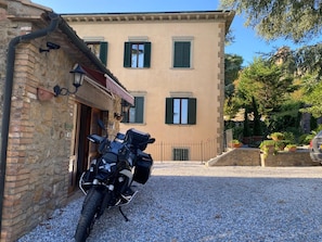 Un edificio con camino de grava y una motocicleta estacionada.