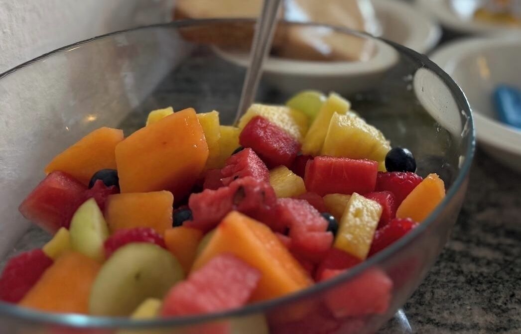 A clear glass bowl filled with mixed fruit salad.