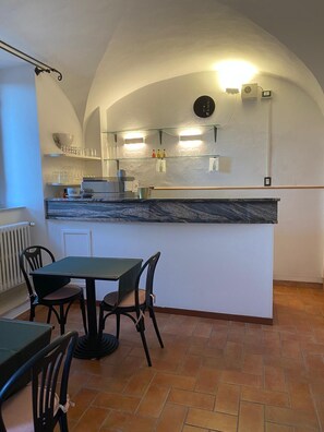 A kitchen with a marble countertop, a clock, and a tiled floor. - Villa Porta all'Arco (Volterra)