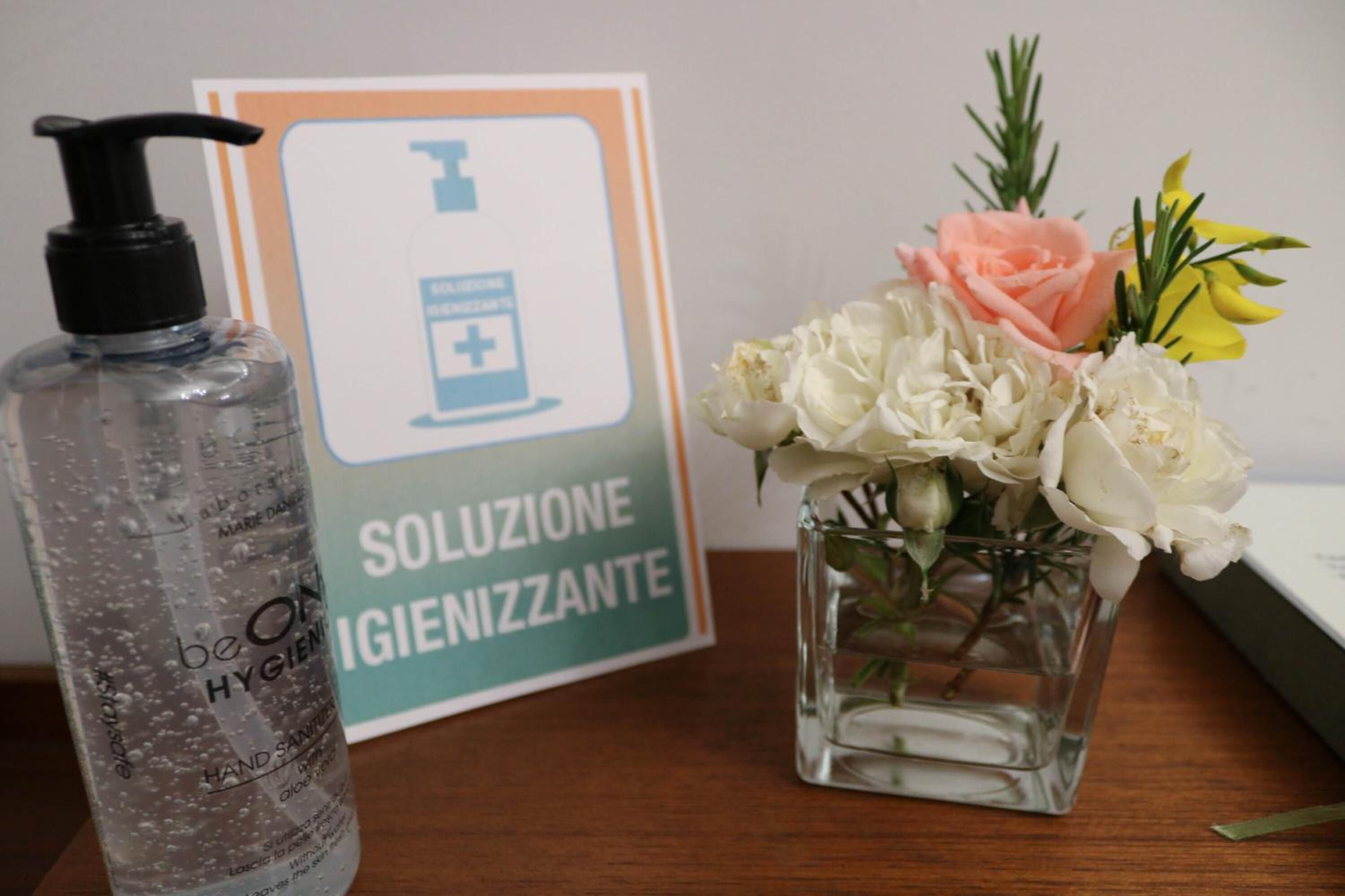 Un flacon de gel hydroalcoolique et une affiche indiquant les consignes d’hygiène.