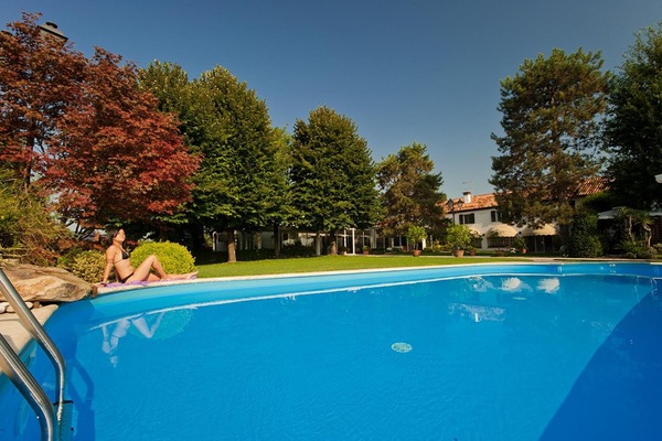 Een buitenzwembad, parasols voor strand/zwembad