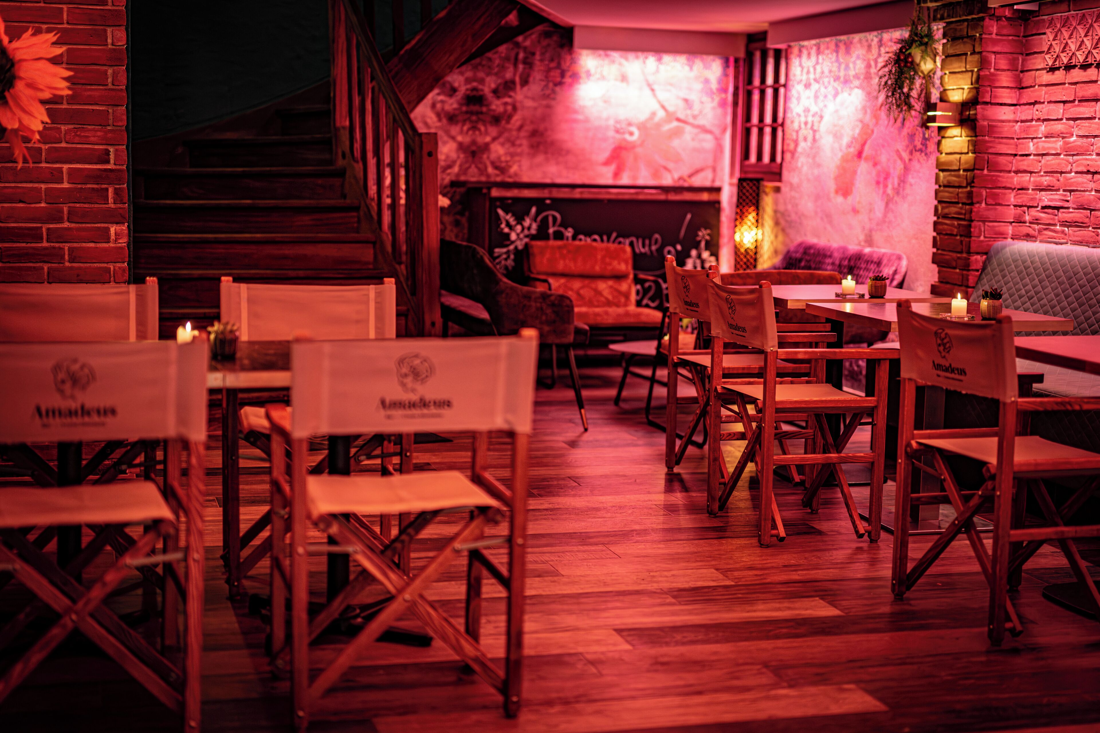 Ein Restaurant mit Holztischen und -stühlen, einer Ziegelwand und einem Wandgemälde an der Rückwand.