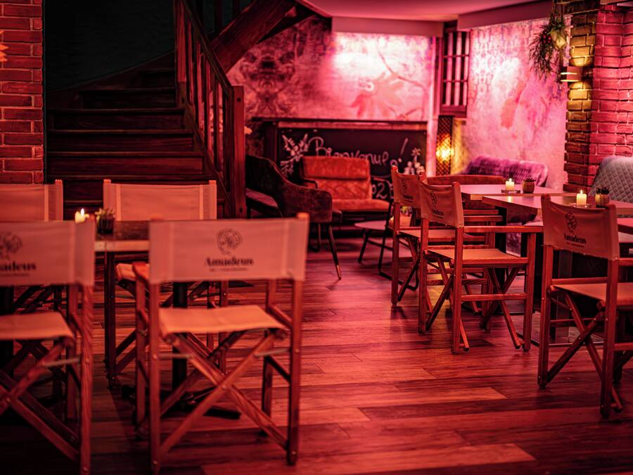 Ein Restaurant mit Holztischen und -stühlen, einer Ziegelwand und einem Wandgemälde an der Rückwand.