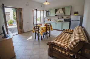 Una cocina con una mesa de comedor y sillas, un sofá y un refrigerador.
