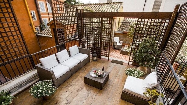 A cozy outdoor seating area with a sofa, a coffee table, and potted plants. - Pettinary Village (Rome)