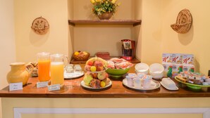 Un buffet della colazione con diverse varietà di frutta, bevande e cereali.