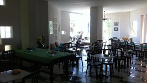 A dining area with multiple tables and chairs, a green tablecloth on one table, and a chandelier. - Marchese d'Altavilla (Drapia)