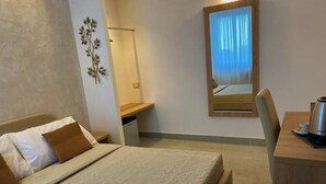 A hotel room with a bed, a desk, a chair, a lamp, and a mirror. - Marchese d'Altavilla (Drapia)