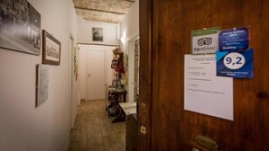 A hallway with a wooden door, a TripAdvisor sign, and a room number 9.2 on the wall. - All'Ombra del Cupolone (Rome)