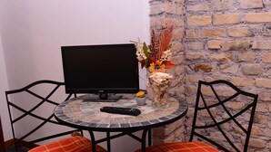 A small, round table with a television, remote control, and decorative vase. - All'Ombra del Cupolone (Rome)