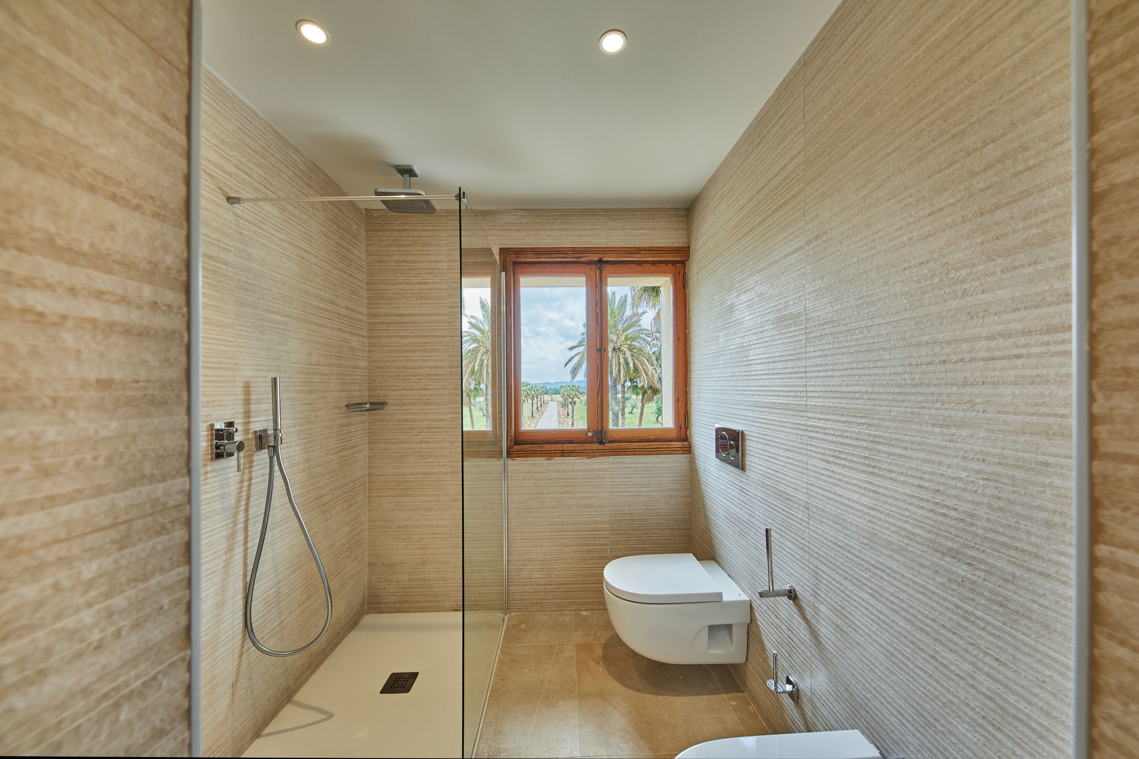 A modern bathroom with a glass-enclosed shower, a toilet, and a sink.