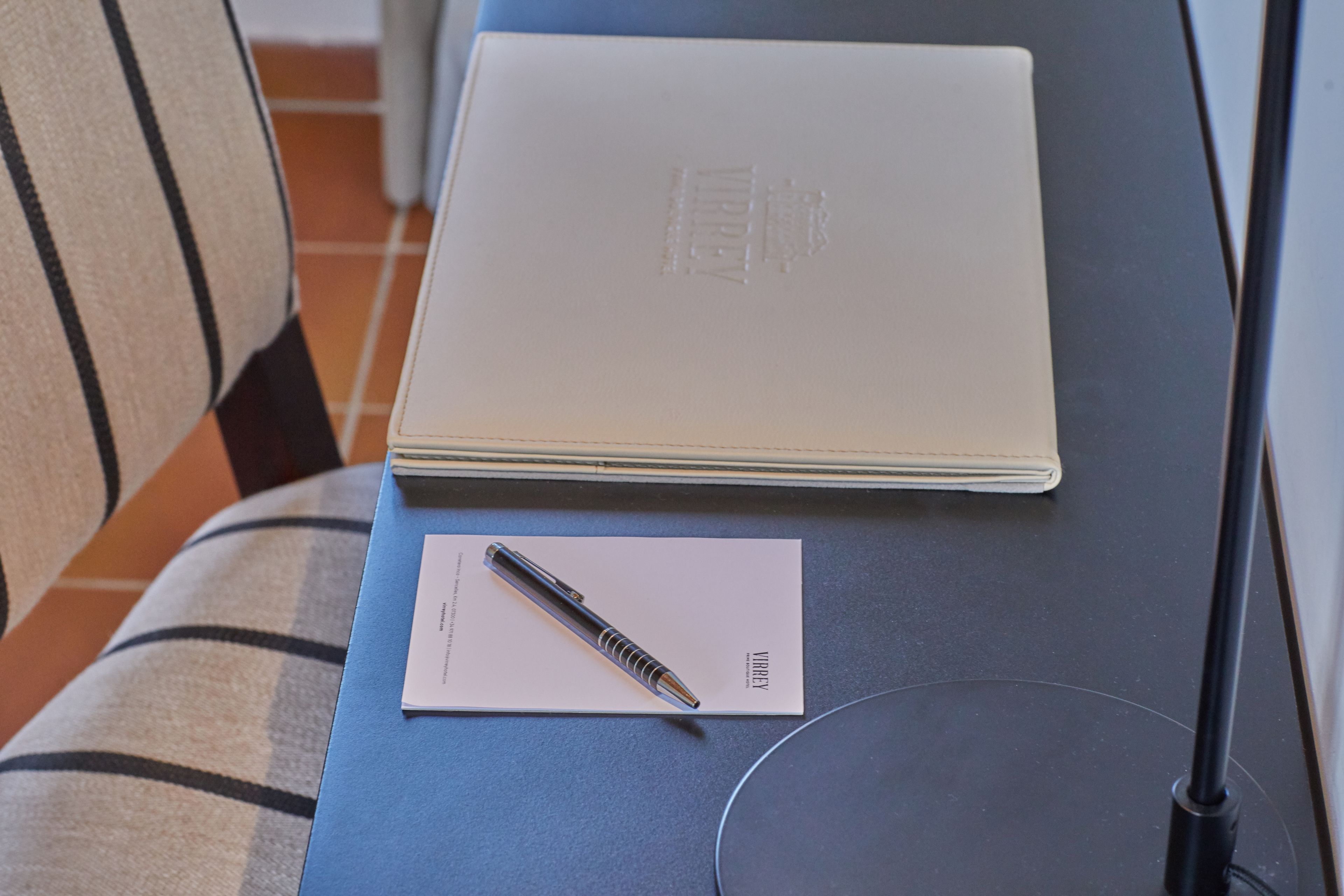 A laptop with a pen and a piece of paper on a table.