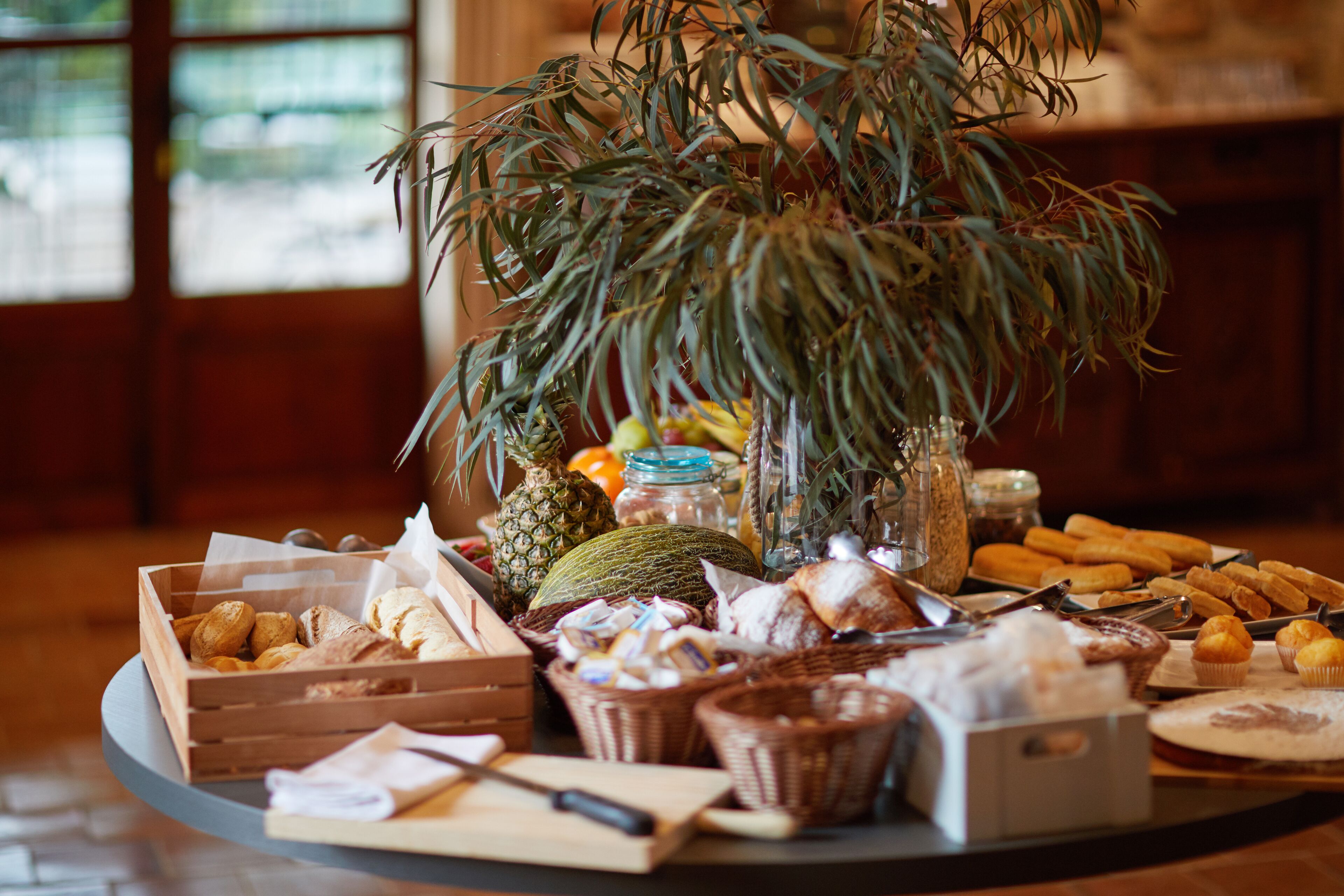 A buffet table with various food items and a potted plant.