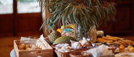 A buffet table with various food items and a potted plant.
