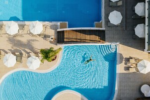 Una piscina techada, 2 piscinas al aire libre, sombrillas
