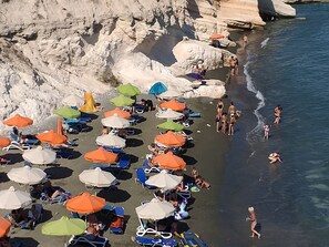 Privatstrand in der Nähe, schwarzer Sandstrand, Strandtücher