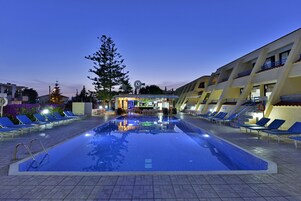 Una piscina al aire libre de temporada, sillones reclinables de piscina