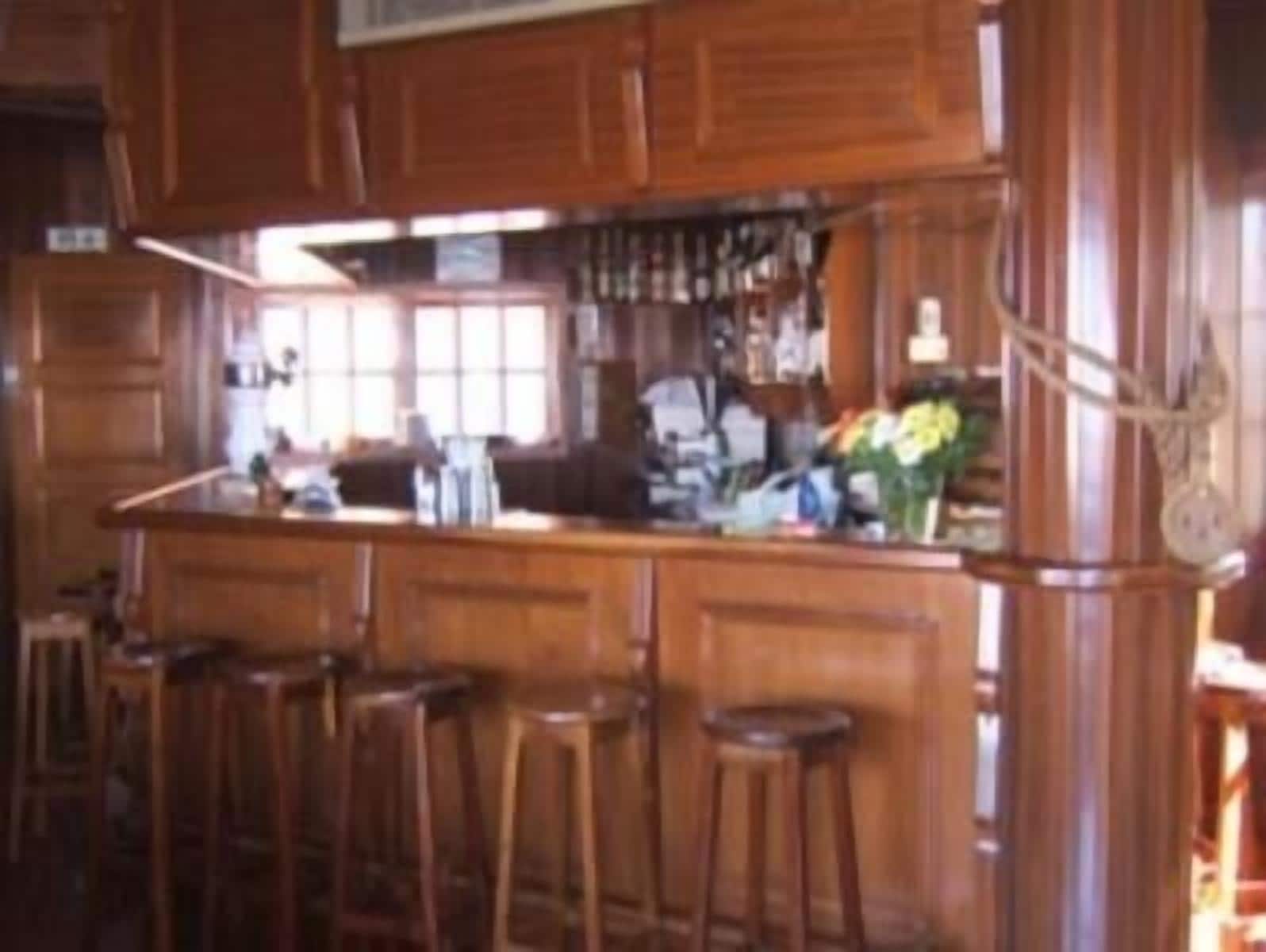 A bar area with wooden bar stools and a counter.
