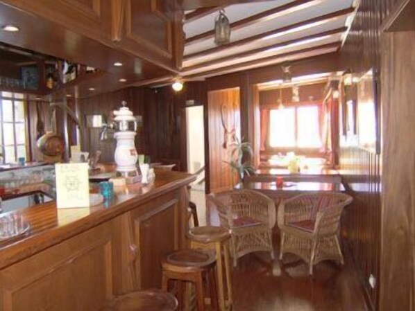 Ein Holzinterieur mit Barbereich, Korbstühlen und einer Theke mit verschiedenen Gegenständen.