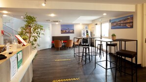 A hotel lobby with a reception desk, seating area, and a bar. - Best Hotel Lyon St Priest (Saint-Priest)