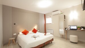 A modern hotel room with a large bed, a desk with a computer, and a small stool. - Best Hotel Lyon St Priest (Saint-Priest)