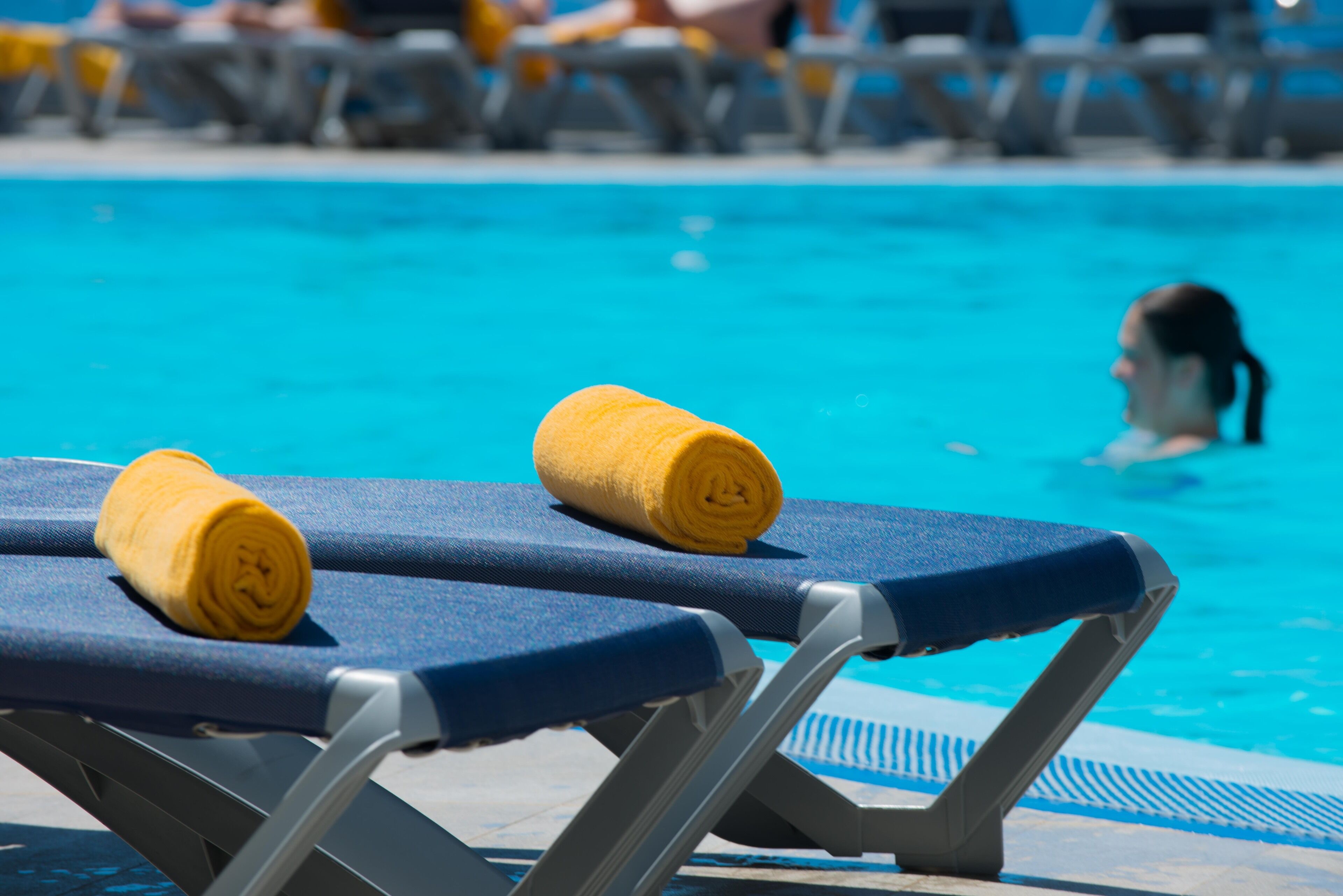 A poolside area with two sun loungers and a towel.