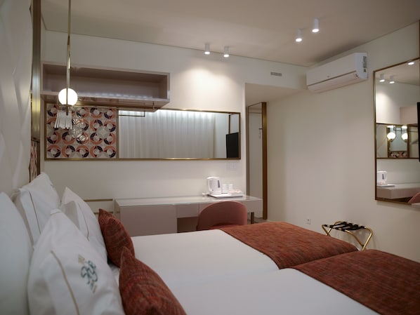 A hotel room with a bed, a desk, a chair, a mirror, and an air conditioning unit. - New Style Lisbon Hotel (Lisbon)