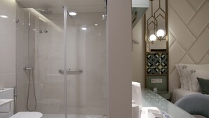 A modern bathroom with a glass-enclosed shower, a toilet, and a vanity with a mirror. - New Style Lisbon Hotel  (Lisbon)